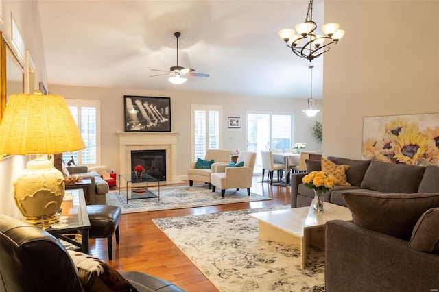 living room with wood-type flooring and ceiling fan with notable chandelier