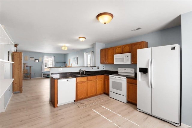 kitchen featuring light hardwood / wood-style floors, white appliances, kitchen peninsula, and sink