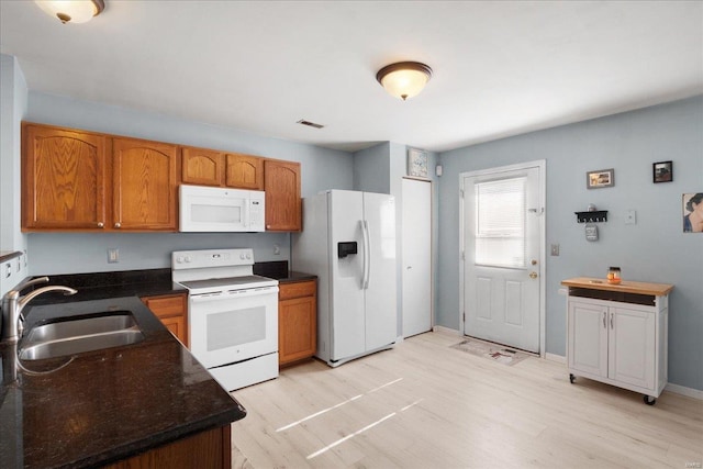 kitchen featuring sink, white appliances, and light hardwood / wood-style floors