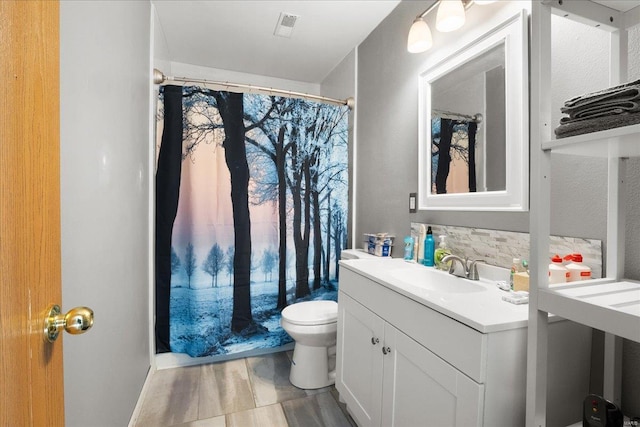 bathroom featuring vanity, toilet, hardwood / wood-style floors, and decorative backsplash