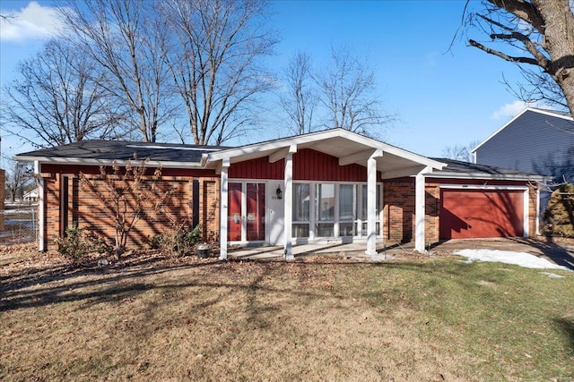 back of property with a yard and a garage