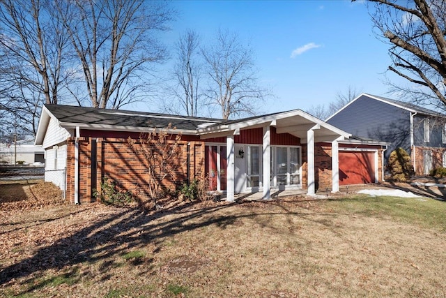 back of property featuring a garage and a yard