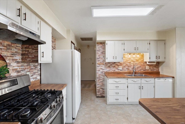 kitchen with stainless steel gas range, sink, white cabinetry, dishwasher, and decorative backsplash