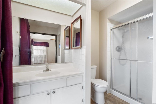 bathroom with vanity, toilet, and a shower with shower door