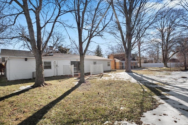 rear view of property featuring a lawn