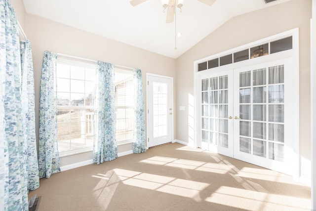 carpeted spare room with lofted ceiling, french doors, and ceiling fan