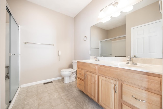 bathroom featuring vanity, an enclosed shower, and toilet