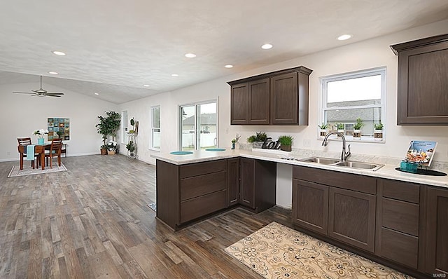 kitchen with dark wood-type flooring, plenty of natural light, vaulted ceiling, and sink