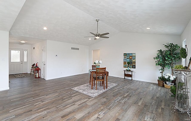 dining space with ceiling fan, dark wood-type flooring, a textured ceiling, and vaulted ceiling