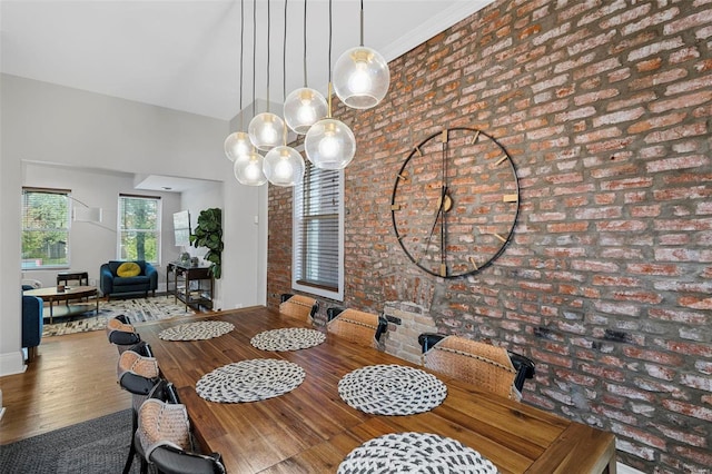 dining space with brick wall and wood-type flooring