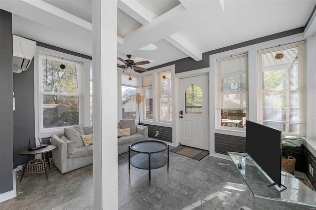 sunroom featuring beamed ceiling, ceiling fan, and a wall unit AC