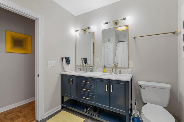 bathroom featuring parquet flooring, vanity, and toilet