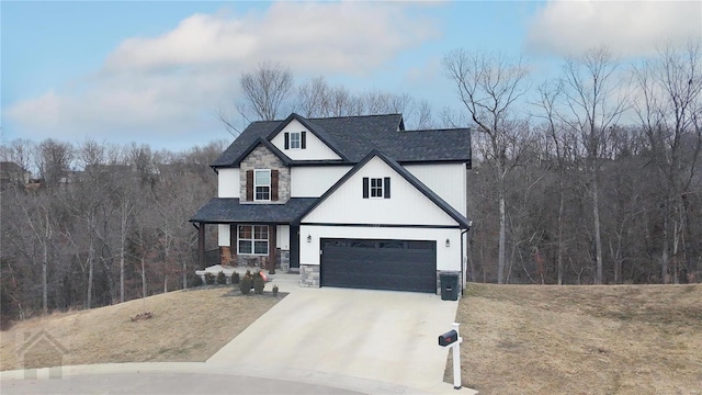 view of front of home with roof with shingles, concrete driveway, a front yard, a garage, and stone siding