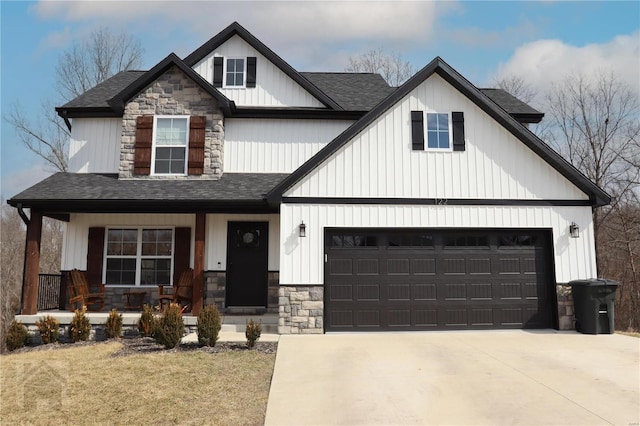 view of front of property featuring driveway, covered porch, stone siding, and roof with shingles