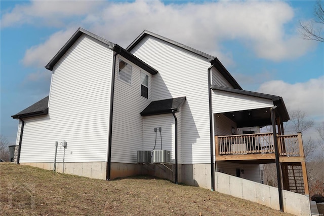 view of home's exterior with cooling unit and a wooden deck