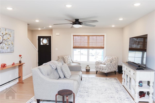 living area featuring light wood-style floors, baseboards, a ceiling fan, and recessed lighting