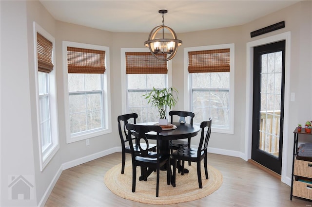 dining space featuring an inviting chandelier, baseboards, and wood finished floors