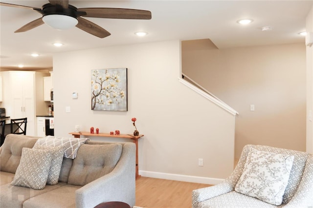 living area with baseboards, ceiling fan, light wood-style flooring, and recessed lighting