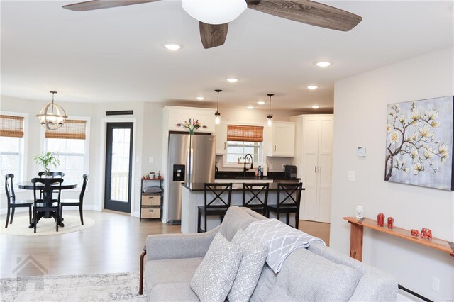 living room with a wealth of natural light, recessed lighting, and wood finished floors