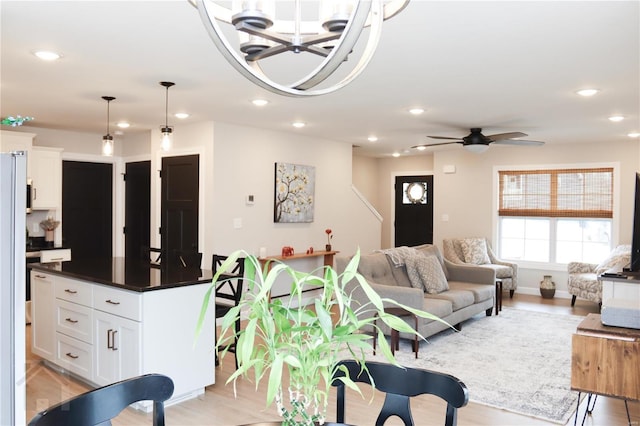 living area featuring light wood finished floors, ceiling fan, baseboards, and recessed lighting