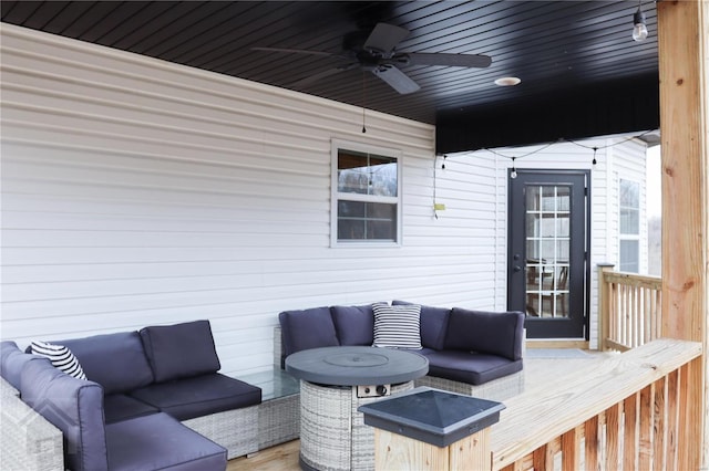 wooden terrace with an outdoor living space and a ceiling fan