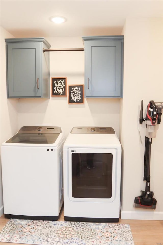 laundry room with cabinet space, baseboards, wood finished floors, washing machine and clothes dryer, and recessed lighting