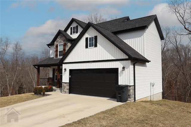 modern farmhouse with a garage, concrete driveway, stone siding, roof with shingles, and covered porch