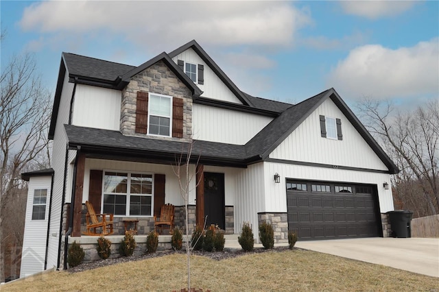 view of front of property featuring stone siding, covered porch, driveway, and roof with shingles