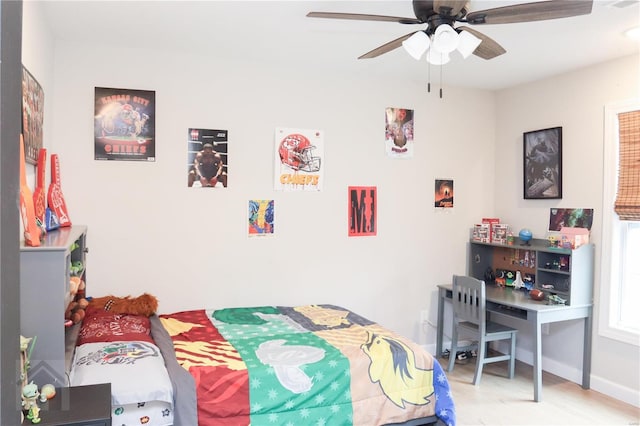 bedroom featuring wood finished floors, a ceiling fan, and baseboards