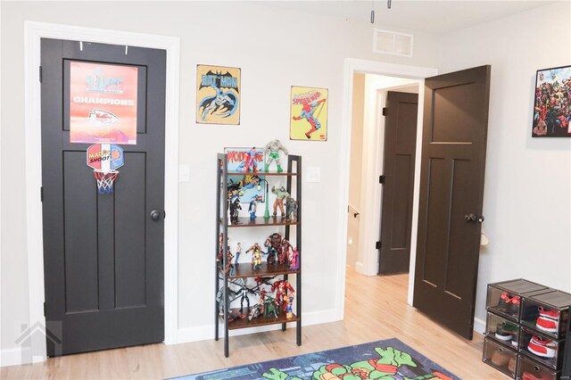 interior space featuring wood finished floors, visible vents, and baseboards