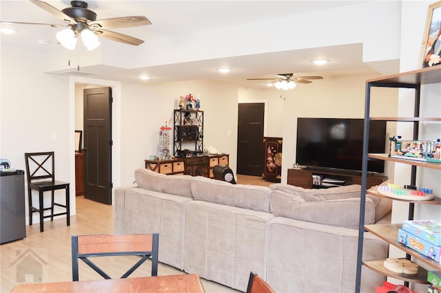 living room with light wood-type flooring, a ceiling fan, and recessed lighting