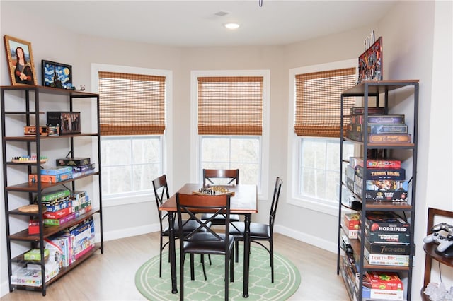 dining space with baseboards, wood finished floors, and recessed lighting