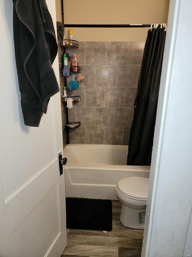 bathroom with shower / tub combo, hardwood / wood-style floors, and toilet