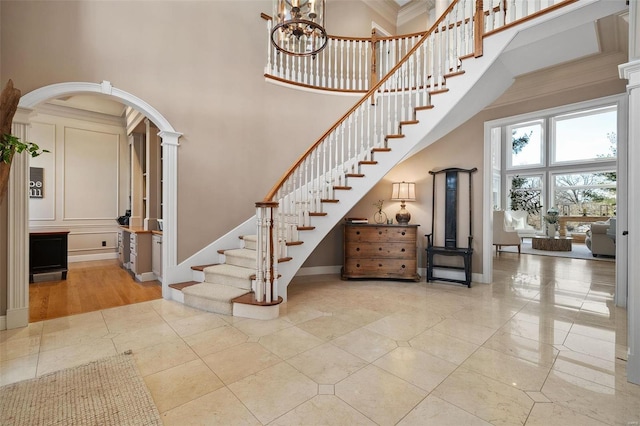 stairway with a towering ceiling and tile patterned floors