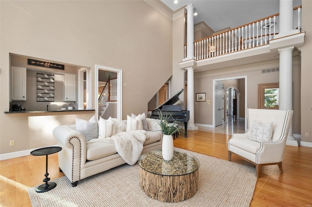 living room featuring decorative columns and light hardwood / wood-style floors