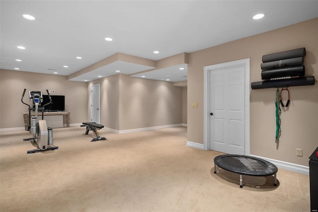 workout room featuring light carpet