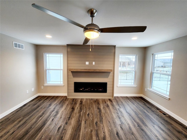 unfurnished living room featuring dark hardwood / wood-style floors, ceiling fan, and a fireplace