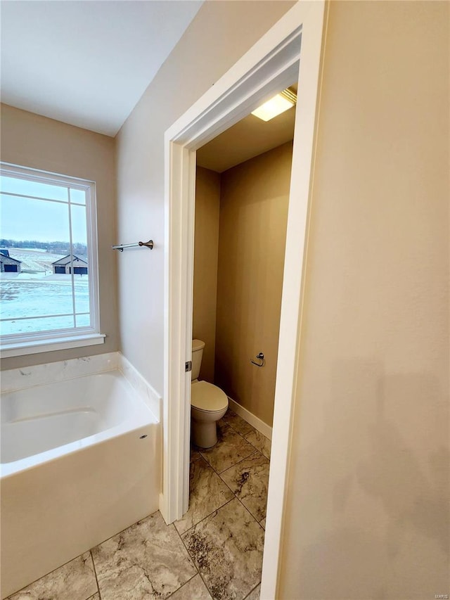 bathroom featuring a tub and toilet