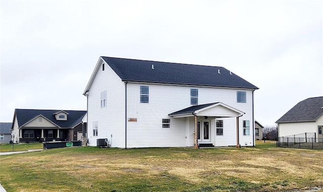 back of house with a yard and central air condition unit