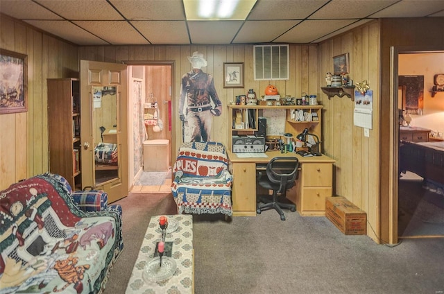 office featuring carpet flooring, a drop ceiling, and wood walls