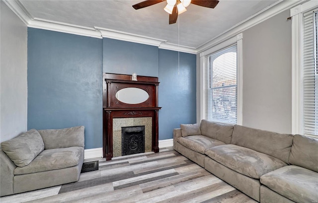 living room featuring ornamental molding, ceiling fan, and light wood-type flooring