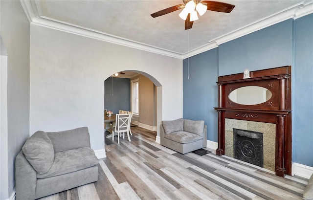 sitting room featuring ornamental molding, ceiling fan, and light wood-type flooring