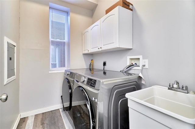 clothes washing area with washer and dryer, dark hardwood / wood-style floors, sink, cabinets, and electric panel