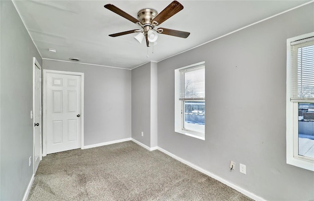 unfurnished room with ceiling fan and carpet