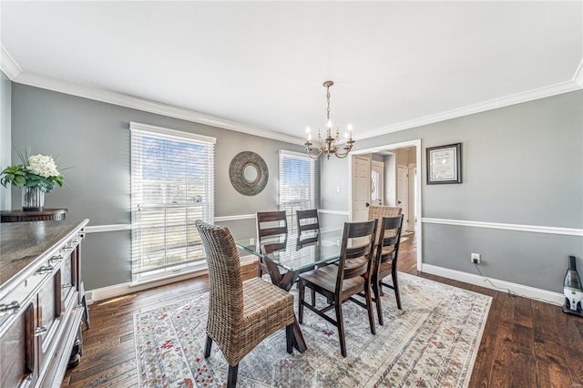 dining space with baseboards, ornamental molding, hardwood / wood-style flooring, and a notable chandelier