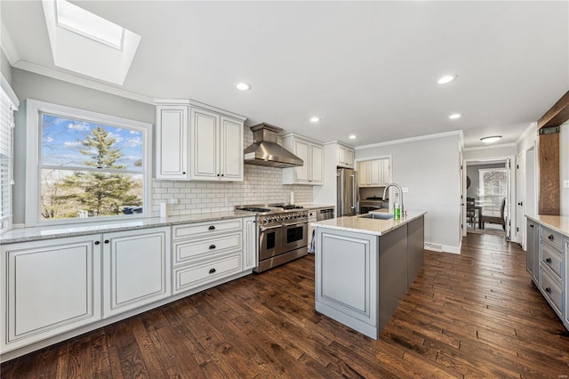 kitchen with stainless steel appliances, a sink, wall chimney range hood, tasteful backsplash, and crown molding