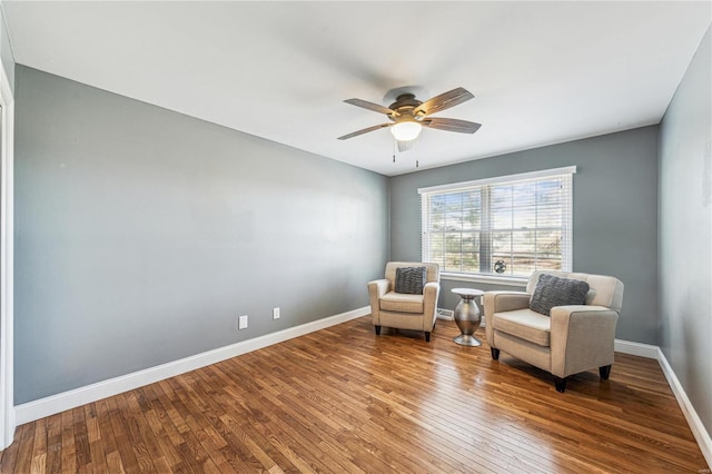 living area featuring ceiling fan, hardwood / wood-style flooring, and baseboards