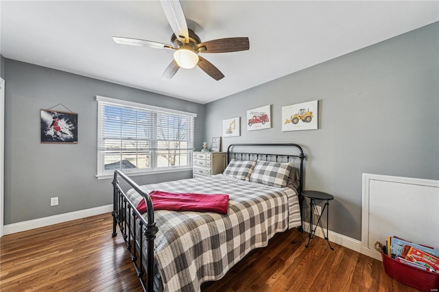 bedroom featuring a ceiling fan, baseboards, and wood finished floors