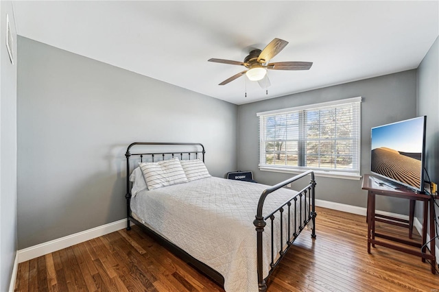 bedroom featuring a ceiling fan, wood-type flooring, and baseboards