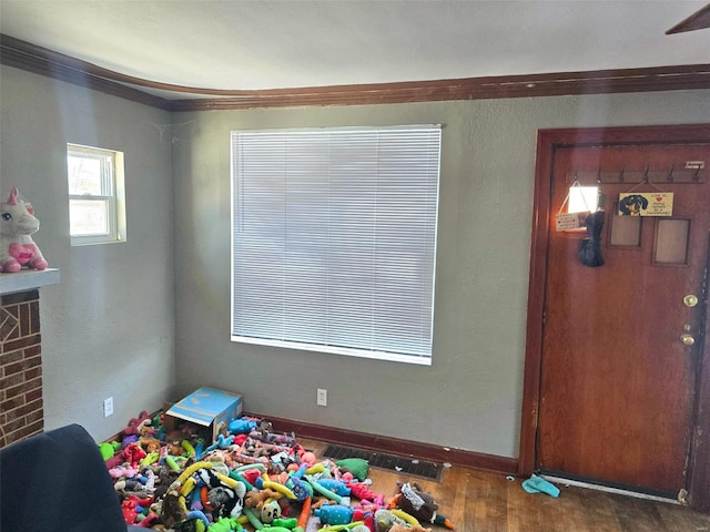 rec room featuring crown molding and dark wood-type flooring